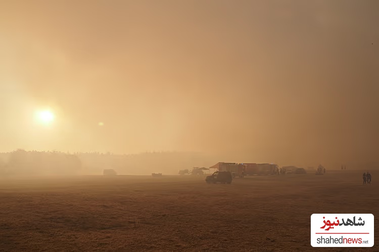 Fire trucks are engulfed in smoke from a forest fire near the hamlet of Großhau in the municipality of Hürtgenwald, Germany, at a staging area. on Friday, Aug. 14, 2026. 